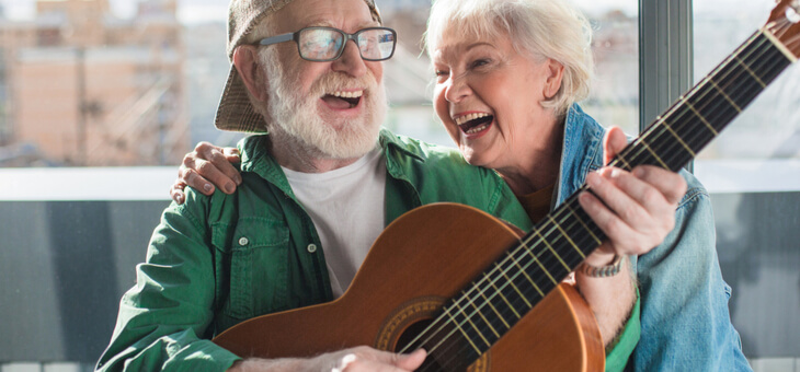 older couple singing and playing guitar