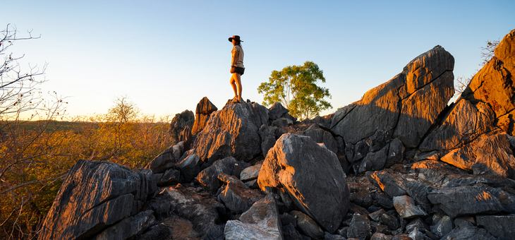 woman standing on large boulder in queensland outback