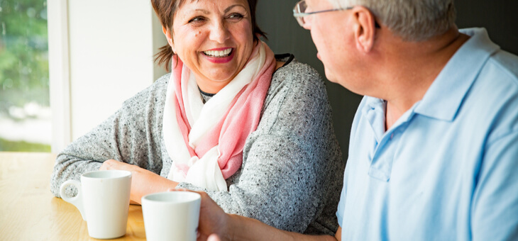 mature couple laughing and drinking coffee