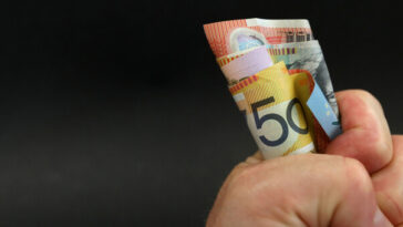 fist holding bunch of australian money