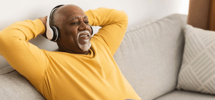 man relaxing on couch with headphones