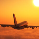 plane flying at sunset