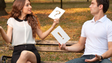 man and woman having argument on park bench