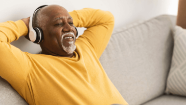 man relaxing on couch with headphones