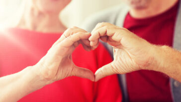 older couple making heart shape by joining hands