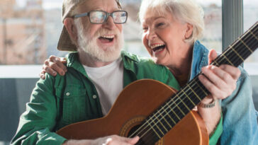 older couple singing and playing guitar