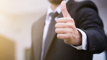 man in suit giving thumbs up