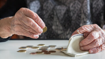 elderly woman counting coins out of purse
