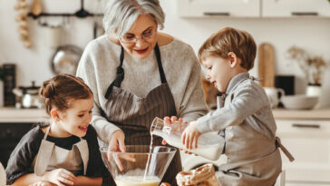 grandmother baking in kitchen with grandchildren