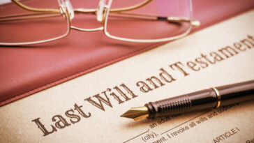 pen resting on last will and testament forms