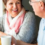 mature couple laughing and drinking coffee