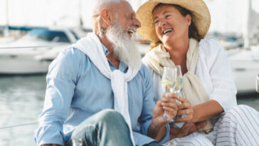 rich older couple drinking champagne on yacht