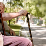 elderly couple sitting on park bench