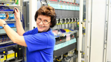 smiling mature woman working in server room