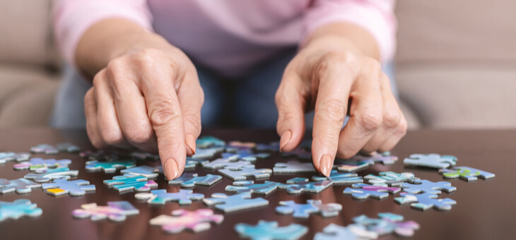 elderly woman doing jigsaw puzzle