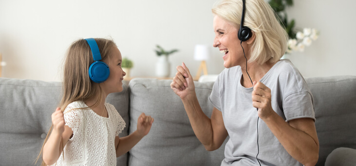 middle aged woman and young girl listening to music with headphones
