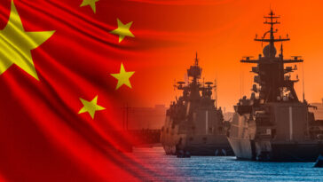 two chinese warships with backdrop of chinese flag