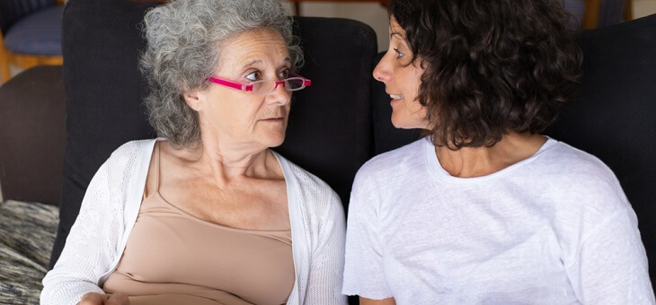 elderly woman having conversation with adult daughter