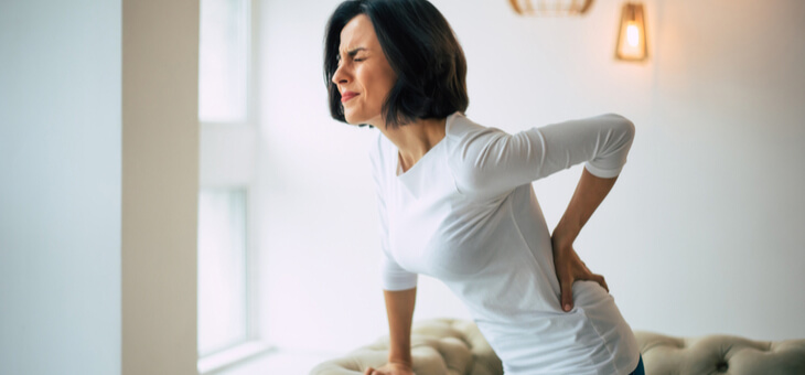 woman holding lower back in pain