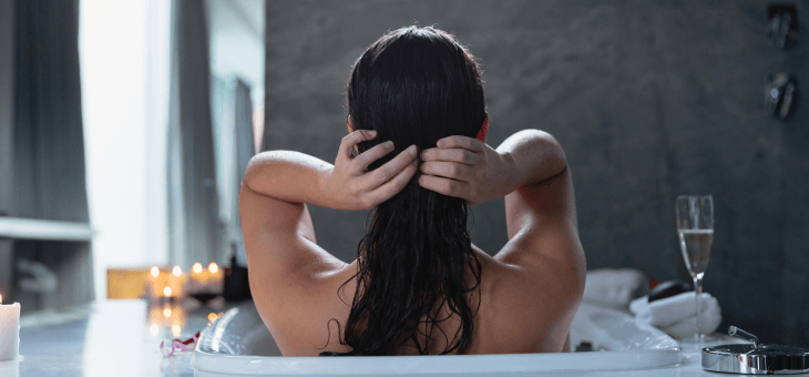 Woman washing her hair in the bath