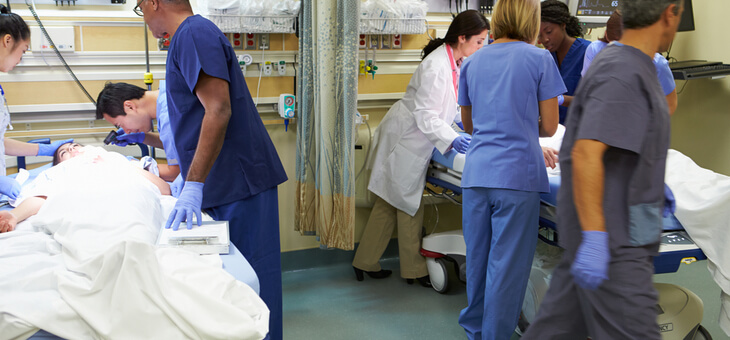 doctors and nurses in scrubs responding to patients in emergency room