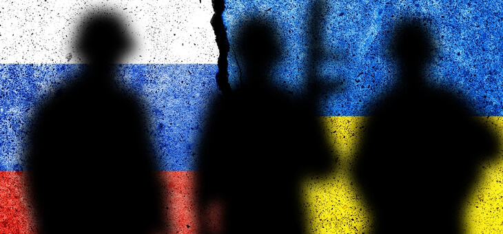 silhouettes of soldiers in front of split Russia-Ukraine flag