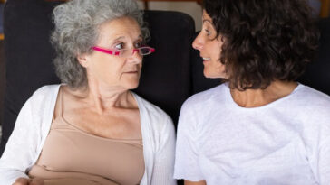elderly woman having conversation with adult daughter