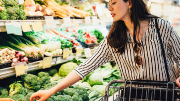 woman shopping in vegetable section of supermarket