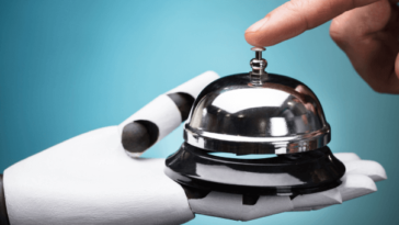 Man ringing hotel desk bell held by a robot