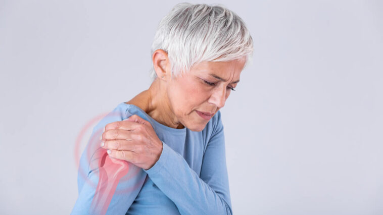 woman holding shoulder in pain