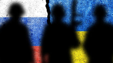 silhouettes of soldiers in front of split Russia-Ukraine flag