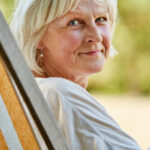 smiling middle aged woman in beach chair