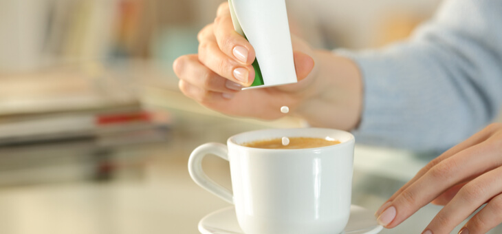 woman putting artificial sweetener in tea