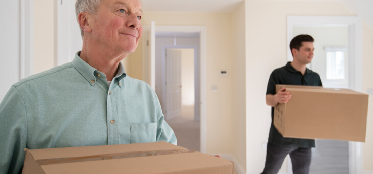 man and his son moving boxes into new home