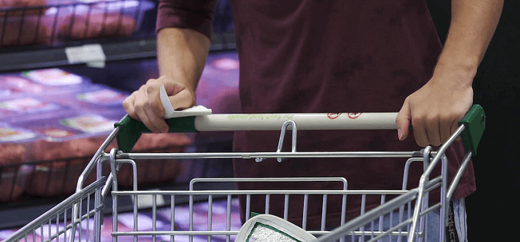 man pushing trolley in supermarket