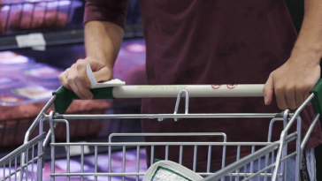 man pushing trolley in supermarket