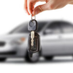 person dangling car keys in front of new car