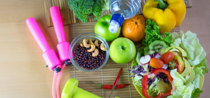 pile of fresh fruit and nuts, vitamins and exercise equipment