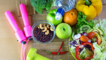 pile of fresh fruit and nuts, vitamins and exercise equipment