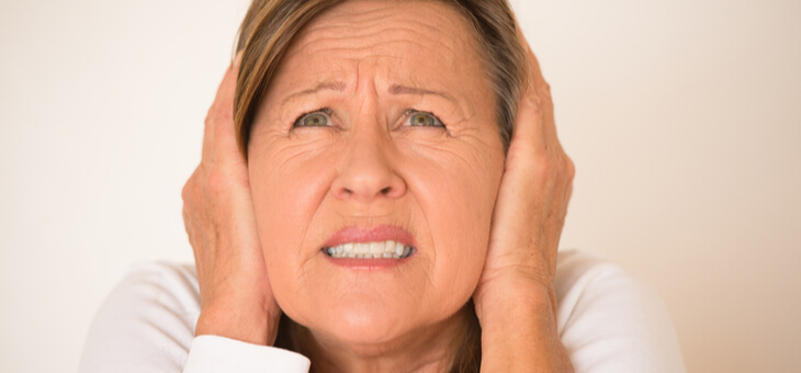 woman covering ears with hands
