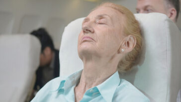 middle aged woman sleeping on flight