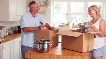 middle aged couple unpacking boxes in new home