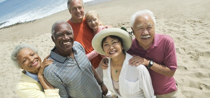 group of baby boomers posing on the beach