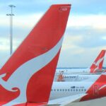 tails of three qantas planes at airport