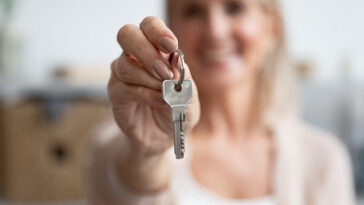 middle aged woman holding keys to house