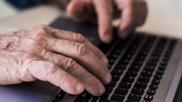 hands of man typing on computer