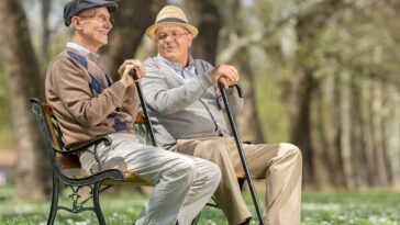 two elderly men sitting on park bench