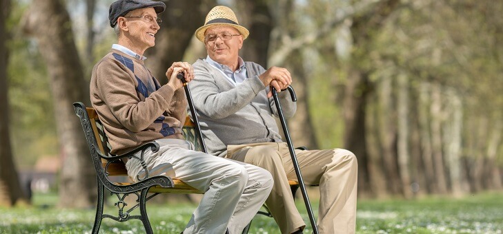 two elderly men sitting on park bench