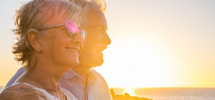happy retired couple outside at sunset