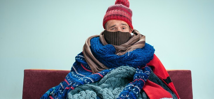 man wrapped in several blankets